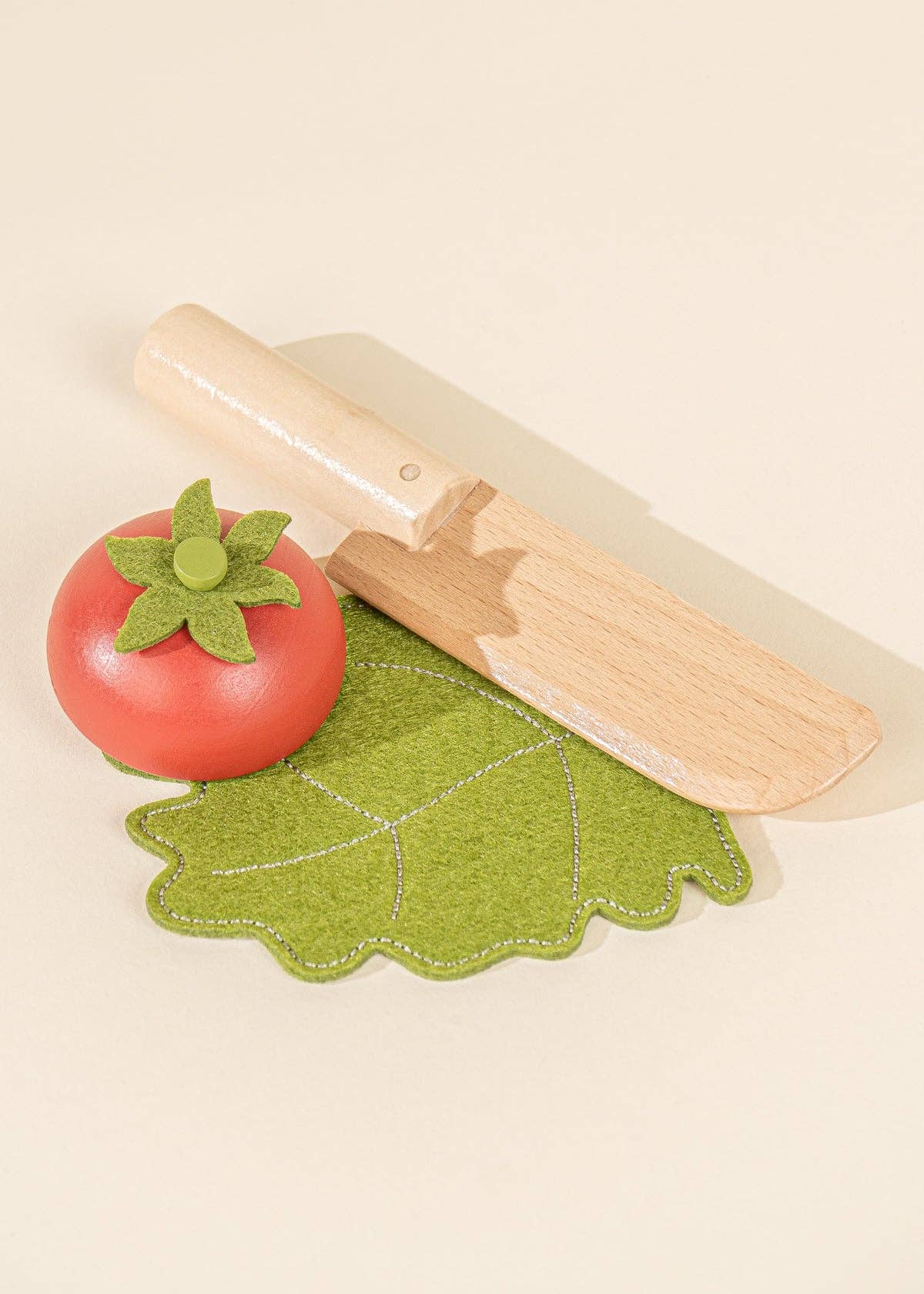 Child playing with Coco Village sliceable wooden vegetables – Montessori kitchen play