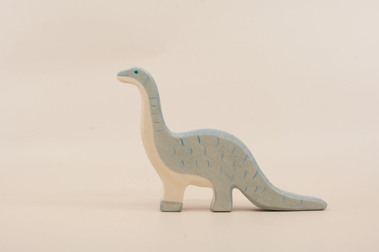 Wooden dinosaur toy on a beige background