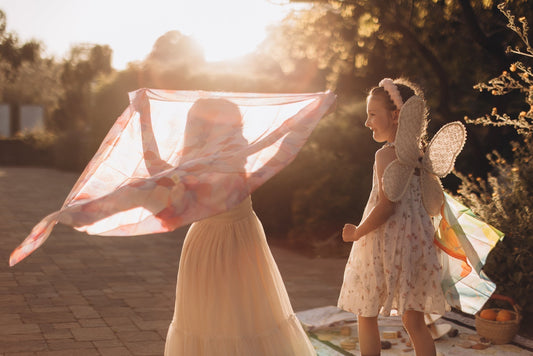 Children playing outdoors with colorful playsilks, encouraging imaginative and open-ended play