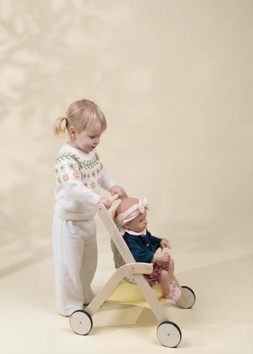 Wooden doll stroller shown in use for pretend play