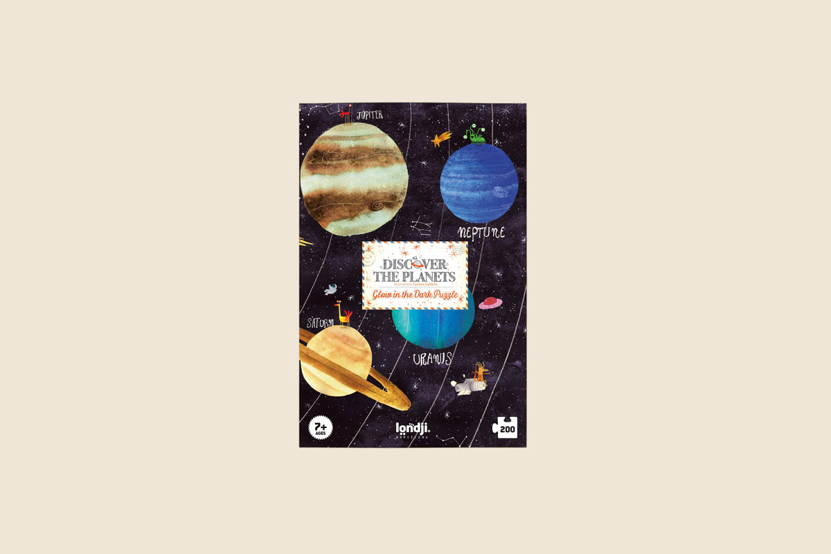 Jigsaw puzzle box with planet illustrations on a beige background