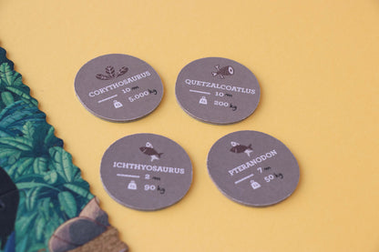 Four round gray labels with dinosaur names and weights on a yellow background