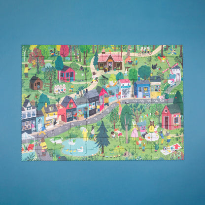 Colorful children's puzzle of a village scene on a blue background