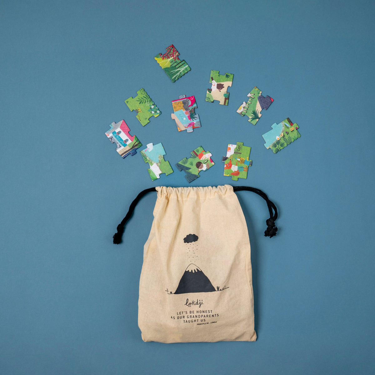 Beige drawstring bag with puzzle pieces on a blue background