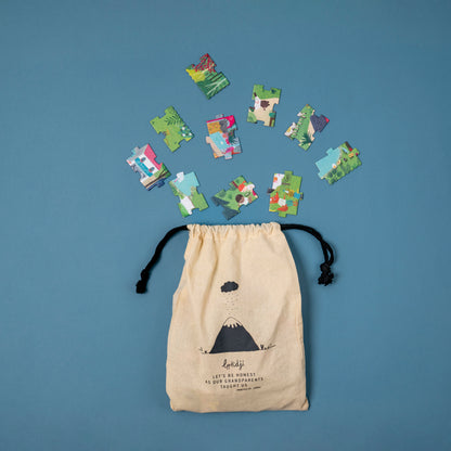 Beige drawstring bag with puzzle pieces on a blue background