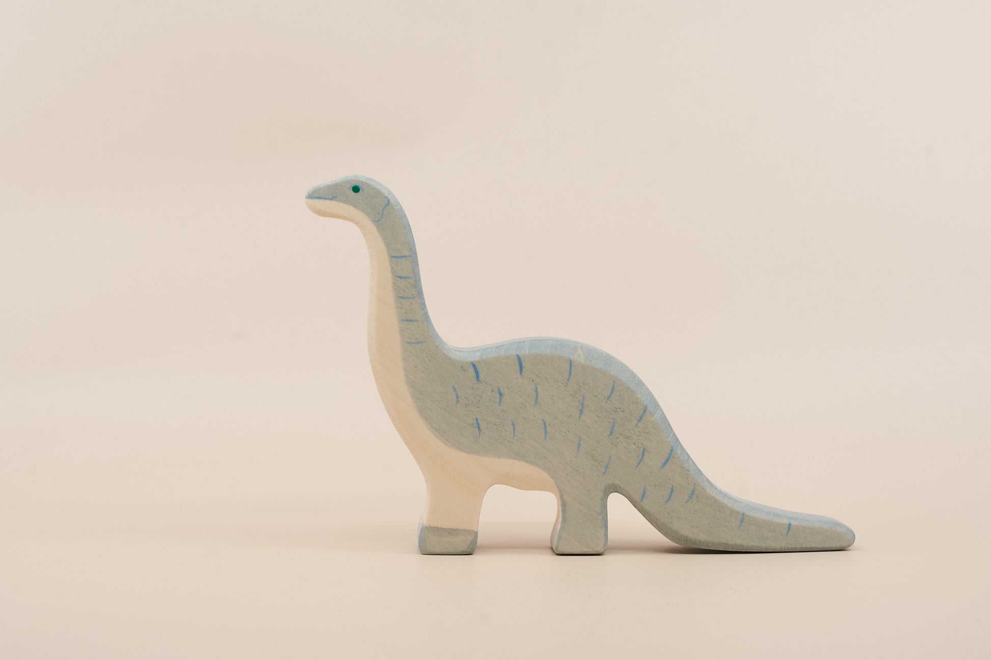 Wooden dinosaur toy on a beige background