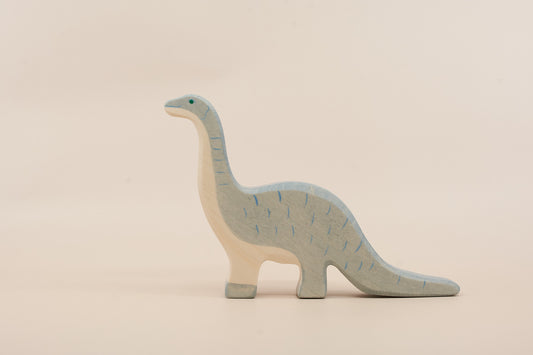 Wooden dinosaur toy on a beige background