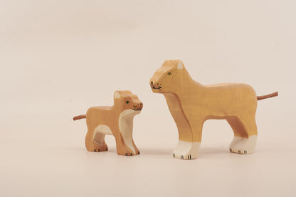 Two wooden lion toys on a beige background
