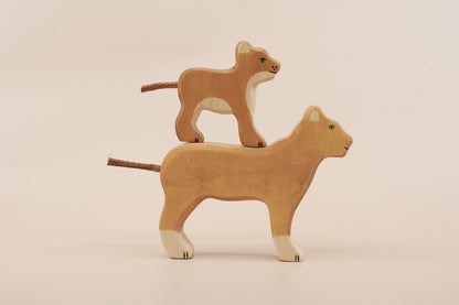 Two wooden lion toys on a beige background