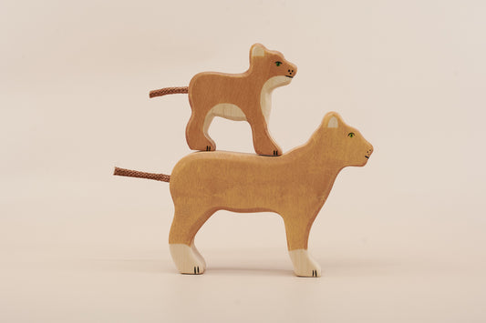 Two wooden lion toys on a beige background