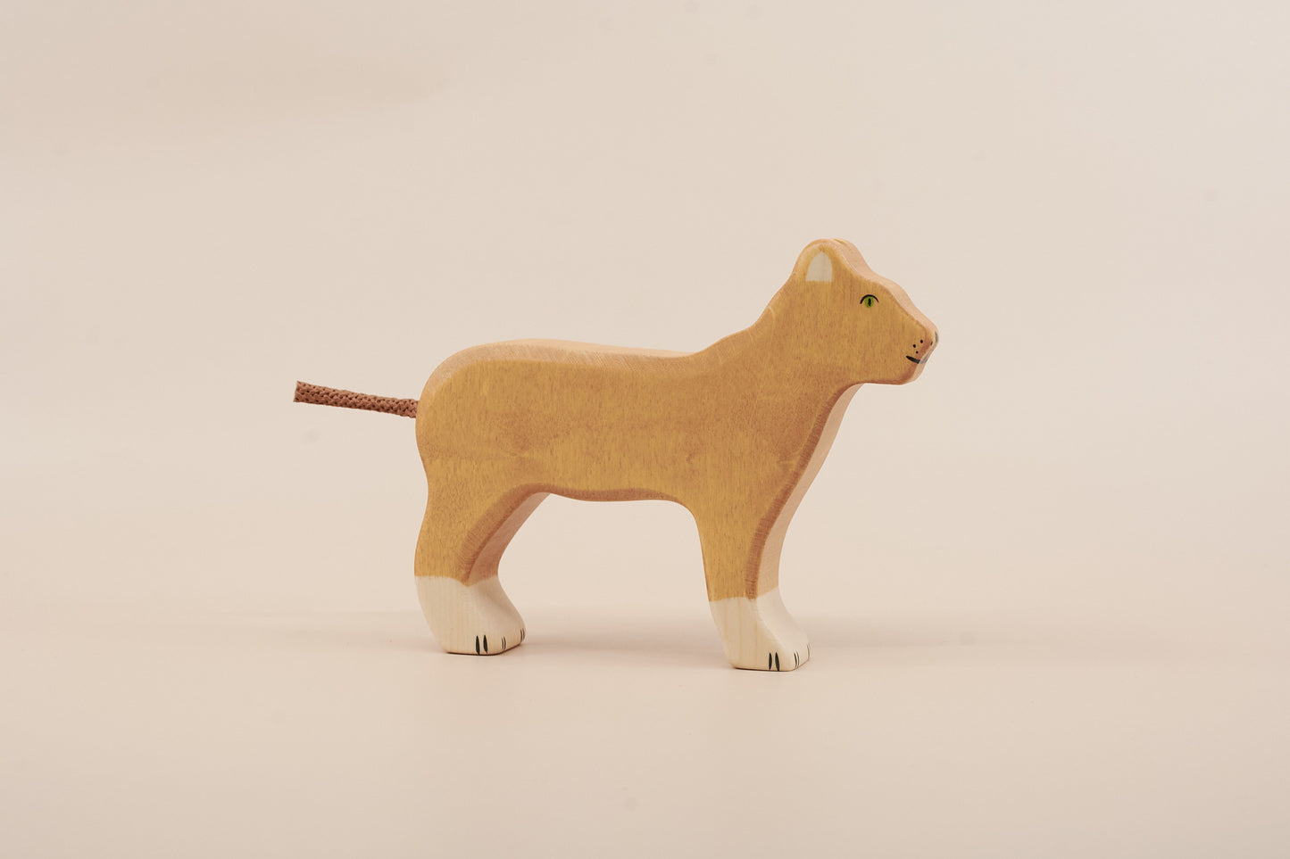 Wooden lion toy on a beige background